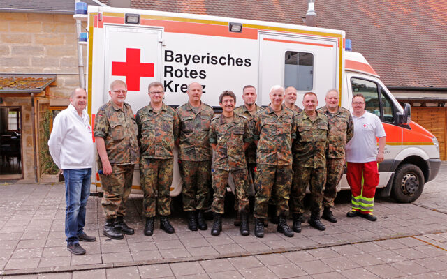 Gruppenbild der Teilnehmer vor Rettungswagen des BRKs.