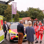 Fahrzeugübergabe an die Helfer-vor-ORt in Aufseß. Bild zeigt neues Einsatzfahrzeug und Teilnehmer der Fahrzeugübergabe.