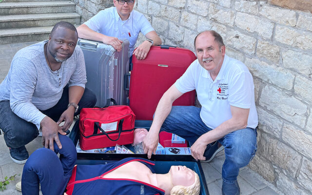 Reanimations-Dummy „Anne“ macht sich auf die Reise. Im Bild (v.l.n.r.): Prinz Ibukun Koussemou (Integrationsbeauftragten der Stadt Bayreuth), Markus Ruckdeschel (Kreisgeschäftsführer des BRK-Kreisverbandes Bayreuth) und Karl Bernet (Projektkoordinator des Defi-Netzwerks der Integrierten Leitstelle Bayreuth/Kulmbach).