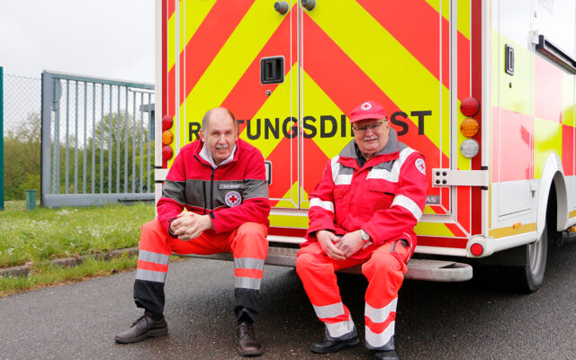 Karl Bernet (l.) und Hermann Mayer (r.) vor einem Rettungswagen.