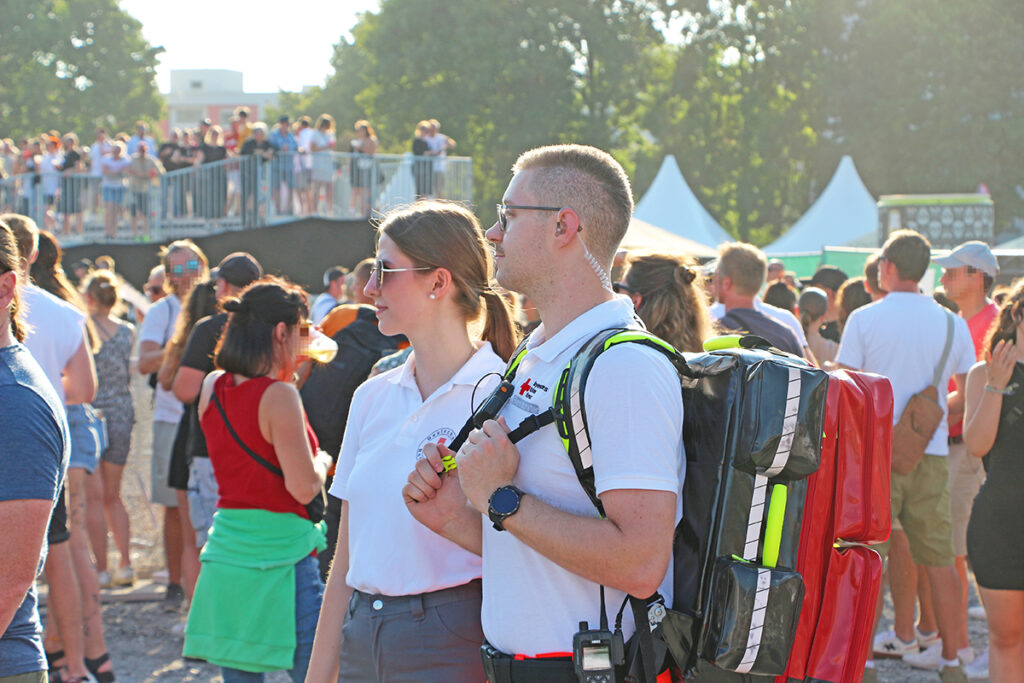 Sanitätsteam zu Fuß patroulliert durch die Besucherinnen und Besucher des Paul Kalkbrenner-Open-Air-Konzertes in Bayreuth.