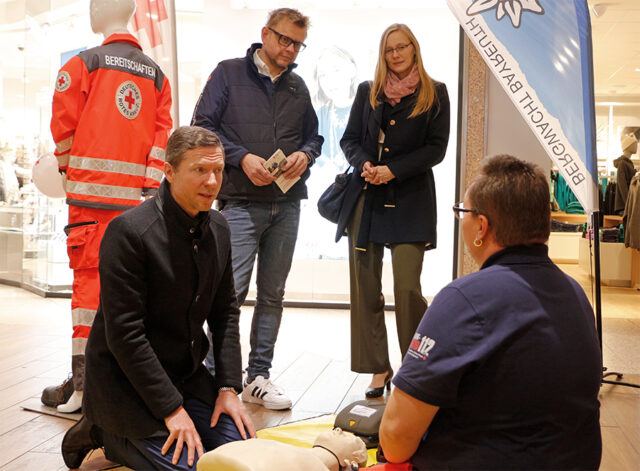 Landrat Florian Wiedemann (Lkr. Bayreuth) informiert sich beim Informations- und Aktionstand des BRK-Kreisverbandes Bayreuth, anlässlich des Tag des Ehrenamtes 2024 im Rotmain-Center Bayreuth, über die Maßnahmen der Wiederbelebung.