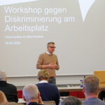 Kreisgeschäftsführer Markus Ruckdeschel vor den Teilnehmenden des Workshops der Antidiskriminierungsberatung von "Füreinander in Oberfranken" (FiO) vor einer Präsentation mit dem Titel "Workshop geggen Diskiminierung am Arbeitsplatz".